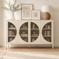 Commode buffet AUBRYNE en métal crème, portes vitrées demi-lune en verre cannelé, dans un salon