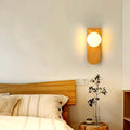 Applique murale en bois naturel au-dessus d'une tête de lit