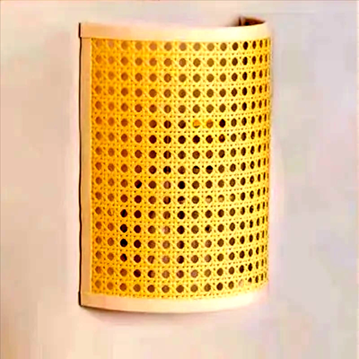 Applique en cannage allumée, lumière chaude filtrée