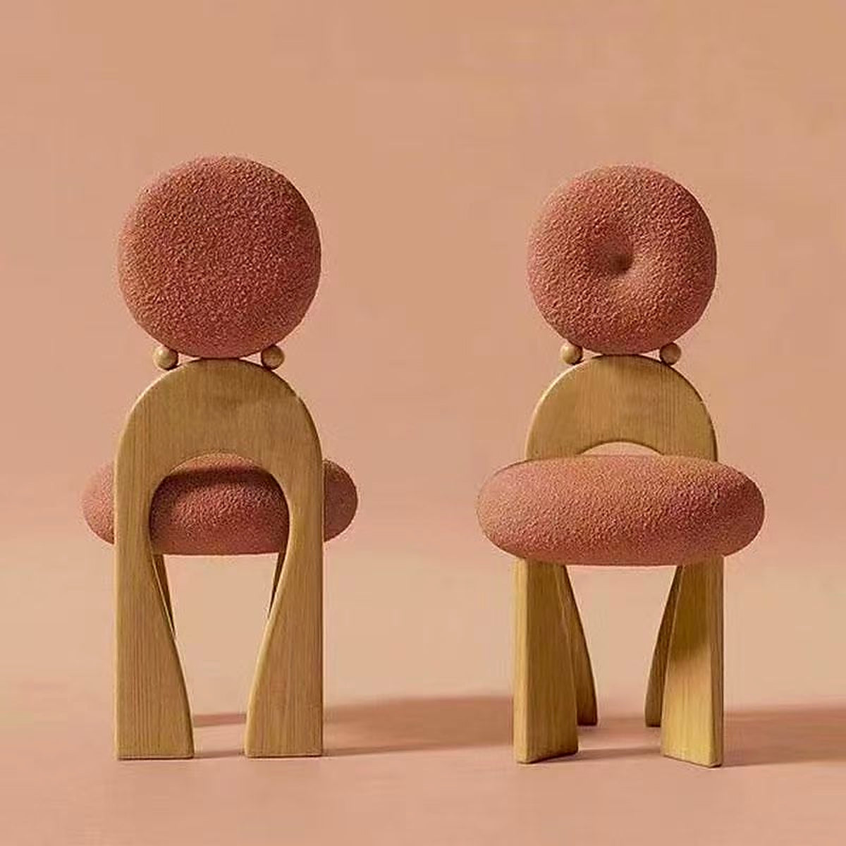 Fauteuil sculptural AUBRYNE en bouclette rose, piètement bois noyer, duo en ambiance