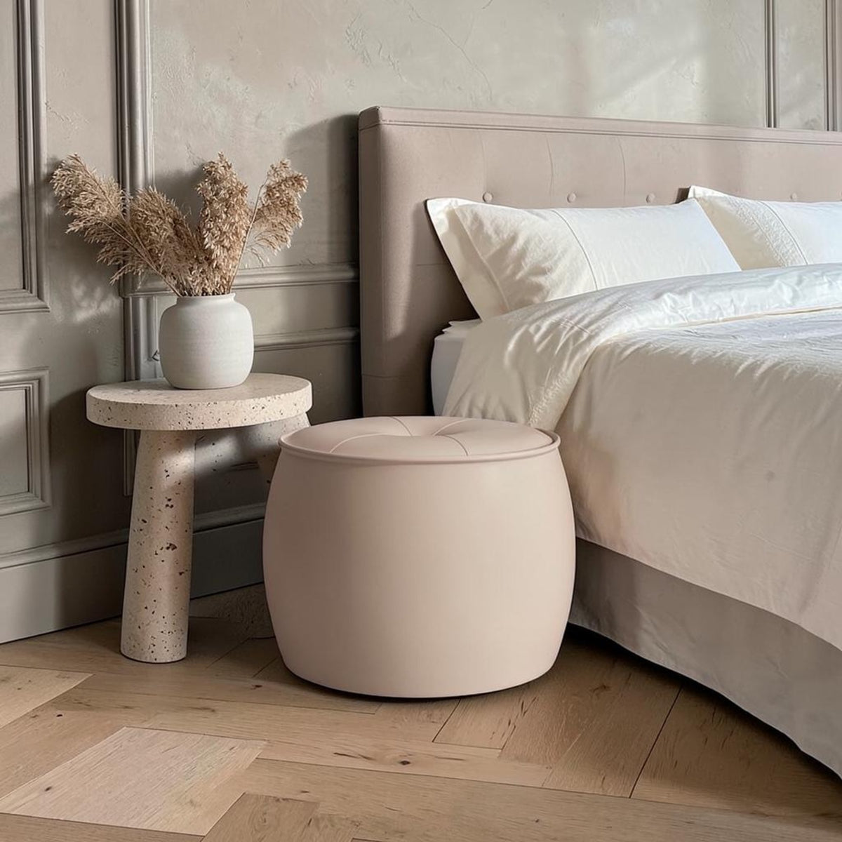 Pouf rond crème au pied du lit
