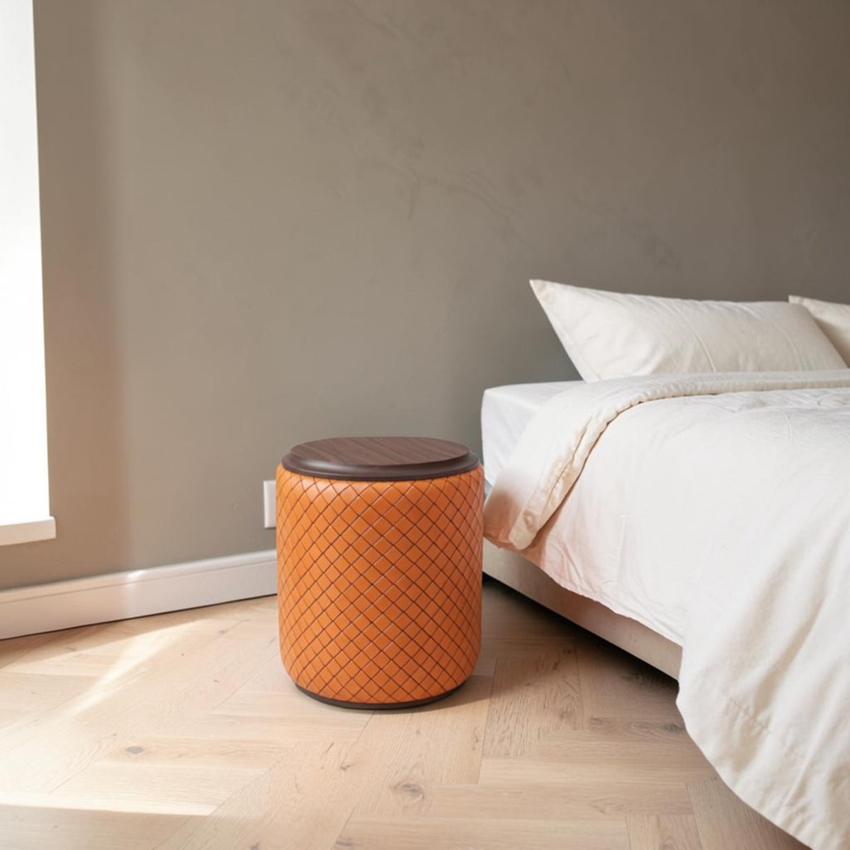 Tabouret rond tressé orange au pied du lit