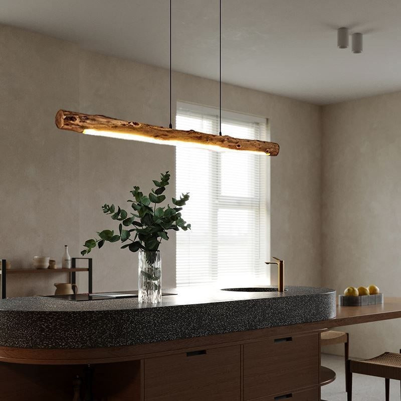 Suspension tronc de bois brut au-dessus d'un îlot de cuisine, avec eucalyptus