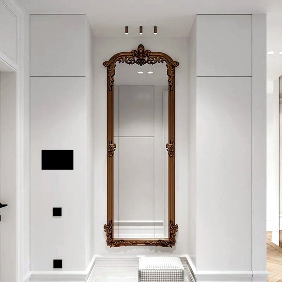 Miroir baroque doré pleine hauteur dans une entrée blanche